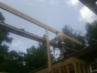 Carpenter setting a ridge beam over a new addition frame — Ice Dam Removal by Roofing Brothers in Center Ossipee