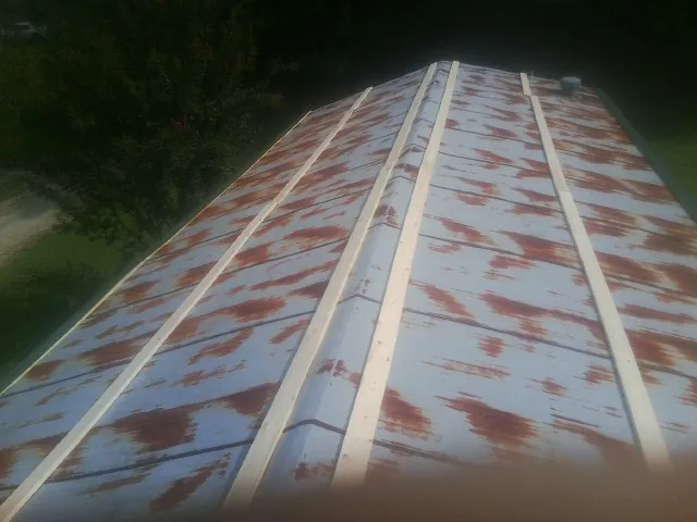 Rusted metal roof panels with new wood purlins before replacement — Storm Damage Roof Repair in Center Ossipee by Roofing Brothers