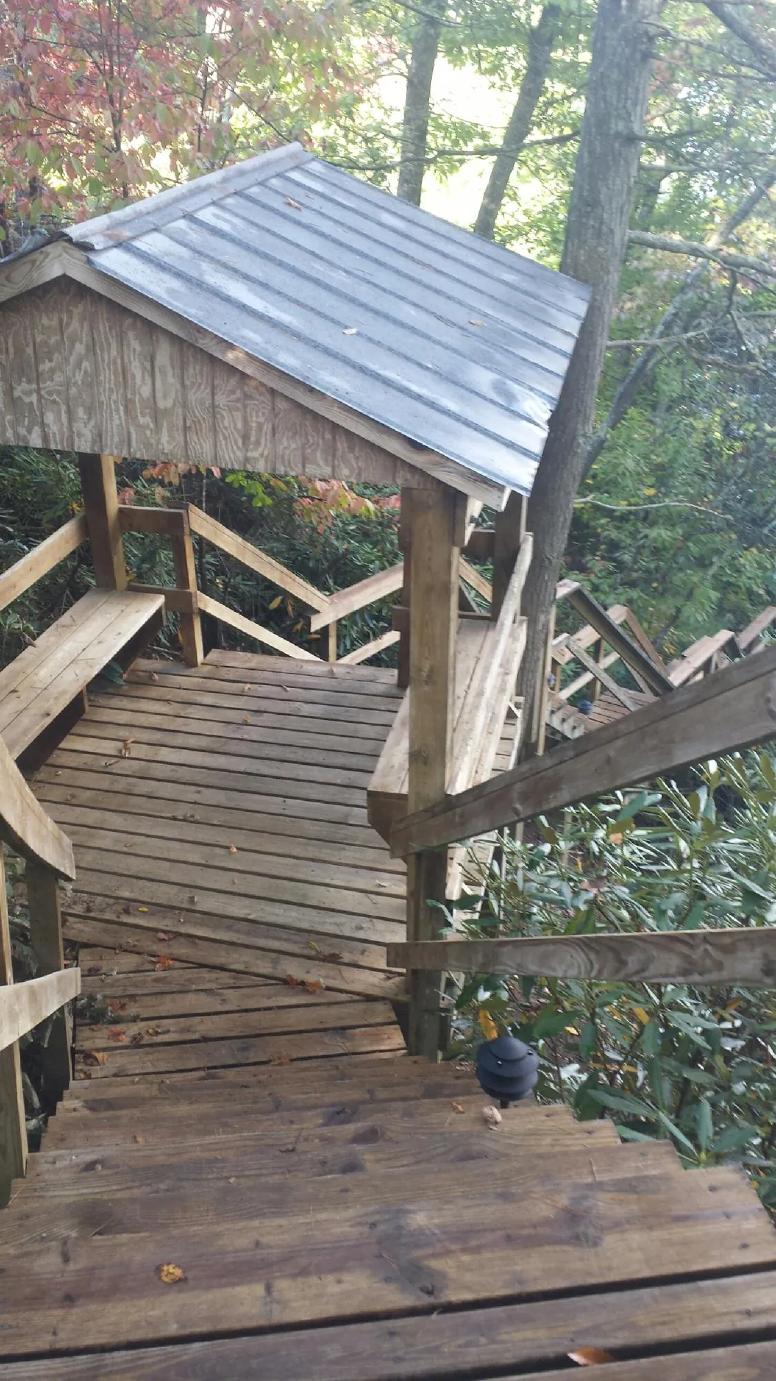 Metal roofed shelter over wooden steps on a wooded walkway — Skylight Repair & Installation work by our crew in Center Ossipee