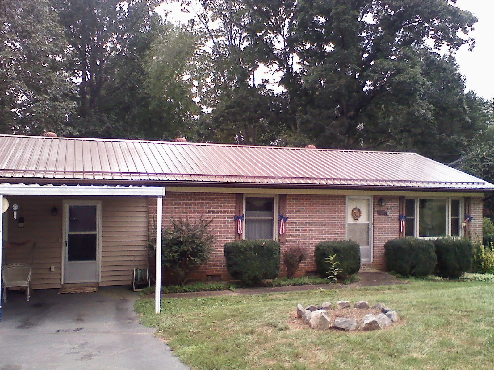 Bronze metal roof and carport on a brick ranch home — Roof Repair work by our crew in Center Ossipee